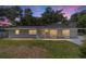 Charming single-story home featuring a well-maintained lawn and cozy front porch and lovely bay window at twilight at 6318 Nw 52Nd Ave, Ocala, FL 34482