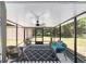 Relaxing screened porch furnished with comfortable seating and a stylish black and white patterned rug at 6318 Nw 52Nd Ave, Ocala, FL 34482