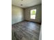 A bedroom with vinyl floors and a window overlooking a grassy area, providing natural light at 6658 Sw 165Th Ct, Ocala, FL 34481