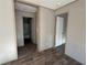 Hallway with entrances to different rooms showcasing neutral-colored walls and contrasting wood-look flooring at 6658 Sw 165Th Ct, Ocala, FL 34481