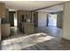 Open-concept kitchen with stainless steel appliances, gray counters, and light wood cabinets leading into the living area at 6658 Sw 165Th Ct, Ocala, FL 34481