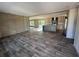 Spacious living room and kitchen area featuring wood trim accents and vinyl flooring at 6658 Sw 165Th Ct, Ocala, FL 34481