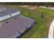 Aerial perspective of a house with a large roof, tidy landscaping, and surrounding green space at 716 Hickory Course Loop, Ocala, FL 34472