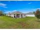 Beautiful backyard with lush green grass, covered patio, and a view of the surrounding greenery at 716 Hickory Course Loop, Ocala, FL 34472