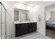 Modern bathroom with double vanity, large mirror, and access to bedroom at 716 Hickory Course Loop, Ocala, FL 34472