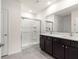 Bathroom featuring double vanity, a large mirror, and a glass-enclosed walk-in shower at 716 Hickory Course Loop, Ocala, FL 34472