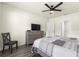 Well-lit bedroom with modern gray dresser, ceiling fan, and plank flooring at 716 Hickory Course Loop, Ocala, FL 34472