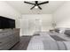 Bedroom features ceiling fan, dresser with TV, and view of ensuite bathroom and walk-in closet at 716 Hickory Course Loop, Ocala, FL 34472