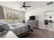 Cozy bedroom with a ceiling fan, dresser with a TV, and a view into the living room at 716 Hickory Course Loop, Ocala, FL 34472