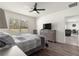 Cozy bedroom with a ceiling fan, dresser with a TV, and a view into the living room at 716 Hickory Course Loop, Ocala, FL 34472