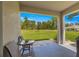 Relaxing covered lanai with seating, offering a view of the lush backyard at 716 Hickory Course Loop, Ocala, FL 34472