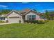 Charming single-story home featuring a well-manicured lawn and beautiful landscaping at 716 Hickory Course Loop, Ocala, FL 34472