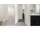 Hallway featuring bathroom and bedroom entrances, neutral walls, and grey tile floor at 716 Hickory Course Loop, Ocala, FL 34472