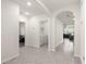 Hallway featuring tile floors, arched doorways, and access to laundry and living areas at 716 Hickory Course Loop, Ocala, FL 34472