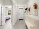 Bright hallway with white bench, decorative wall art, and view into a bedroom at 716 Hickory Course Loop, Ocala, FL 34472