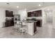 Bright kitchen features dark wood cabinetry, stainless steel appliances, granite counters, and center island with seating at 716 Hickory Course Loop, Ocala, FL 34472