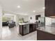 Open-concept kitchen with dark wood cabinets, stainless appliances and granite countertops at 716 Hickory Course Loop, Ocala, FL 34472