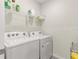 Efficient laundry room with a Whirlpool washer and dryer, and shelving for storage at 716 Hickory Course Loop, Ocala, FL 34472