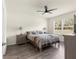 Bright main bedroom boasts wood flooring, neutral paint, large window, ceiling fan, and wood furniture at 716 Hickory Course Loop, Ocala, FL 34472