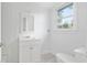 This bright bathroom features a sink, vanity, mirror, toilet, and a window at 721 Ne 2Nd St, Ocala, FL 34470