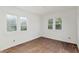 A light filled bedroom with hardwood floors and ample natural light from two windows at 721 Ne 2Nd St, Ocala, FL 34470