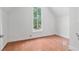 A bedroom with wood floors, white walls, and a large window with view at 721 Ne 2Nd St, Ocala, FL 34470