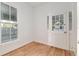 Sunlit room featuring hardwood floors, white walls, and a door with glass panes, providing ample natural light at 721 Ne 2Nd St, Ocala, FL 34470