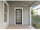 A porch view of a front door with glass panes, complemented by a window and a wooden deck at 721 Ne 2Nd St, Ocala, FL 34470