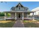 Charming two-story home featuring a full front porch with sturdy support columns and a classic brick pathway at 721 Ne 2Nd St, Ocala, FL 34470