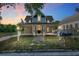 Inviting two-story home featuring a charming covered porch, well-maintained lawn, and a welcoming ambiance at 721 Ne 2Nd St, Ocala, FL 34470