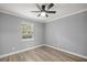 Cozy bedroom features gray walls, wood-look floors, and a window with natural light at 7585 Sw 79Th Pl, Ocala, FL 34476