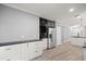 Modern kitchen with white cabinets, stainless steel appliances, black countertops, and wood-look flooring at 7585 Sw 79Th Pl, Ocala, FL 34476
