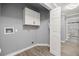 Functional laundry room with ample cabinet space, gray walls and wood-look floors at 7585 Sw 79Th Pl, Ocala, FL 34476