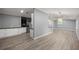 Open floor plan showcasing gray walls, wood-look floors, stylish lighting and access to the kitchen at 7585 Sw 79Th Pl, Ocala, FL 34476