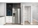 Kitchen pantry with stainless steel refrigerator and adjustable metal shelving at 7585 Sw 79Th Pl, Ocala, FL 34476