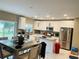 Spacious kitchen featuring white cabinets, stainless steel appliances, island with seating, and dining area at 807 Glen Creek Ct, Fruitland Park, FL 34731