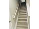 Staircase with white risers and wood treads creating a modern aesthetic and providing access to upper level at 807 Glen Creek Ct, Fruitland Park, FL 34731