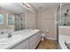 Bright bathroom featuring double sink vanity, shower and a soaking tub at 8127 Sw 60Th Ct, Ocala, FL 34476