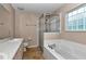 Bathroom featuring double vanity, shower with glass door and a soaking tub at 8127 Sw 60Th Ct, Ocala, FL 34476