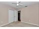 Bedroom with a ceiling fan, carpet, closet, and a door leading to another room at 8127 Sw 60Th Ct, Ocala, FL 34476