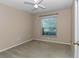 Cozy bedroom with neutral carpet, ceiling fan and a window providing natural light at 8127 Sw 60Th Ct, Ocala, FL 34476