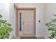 Inviting front entrance featuring a classic door, sidelight window, and leafy greenery at 8127 Sw 60Th Ct, Ocala, FL 34476