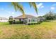 Spacious backyard view highlighting a sunroom, complemented by verdant landscaping and an adjacent fence line at 8632 Sw 86Th Cir, Ocala, FL 34481