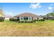 Expansive backyard featuring a sunroom, lush green lawn, and well-manicured landscaping; ideal for outdoor activities at 8632 Sw 86Th Cir, Ocala, FL 34481