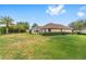 A wide shot of the spacious backyard showing lush lawn and tropical landscaping at 8632 Sw 86Th Cir, Ocala, FL 34481