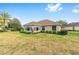 The backyard shows a bright sunroom, green grass, and surrounding green landscaping at 8632 Sw 86Th Cir, Ocala, FL 34481