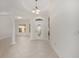 Bright entryway showcasing neutral-toned tile flooring and an elegant light fixture, complemented by a decorative front door at 8632 Sw 86Th Cir, Ocala, FL 34481
