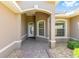 Close-up of the front entrance featuring a white front door and a brick pathway with landscaped features at 8632 Sw 86Th Cir, Ocala, FL 34481