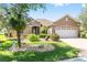 Charming single-story home featuring a well-manicured lawn, mature trees, and a brick driveway leading to a two-car garage at 8632 Sw 86Th Cir, Ocala, FL 34481