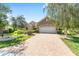 Single-story home featuring a brick driveway, a two-car garage, and manicured landscaping, enhancing its curb appeal at 8632 Sw 86Th Cir, Ocala, FL 34481